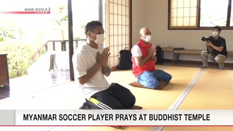 Myanmar soccer player prays at Buddhist temple